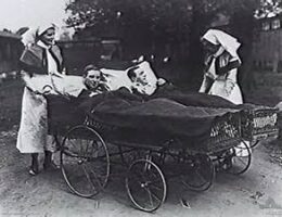 Nursing sisters taking patients, in portable beds, out for air
